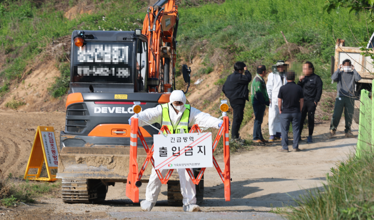 구제역이 발생한 11일 충북 청주시 청원구 북이면의 한 한우농장에서 방역본부 직원이 출입 통제 안내판을 설치하고 있다. [연합]