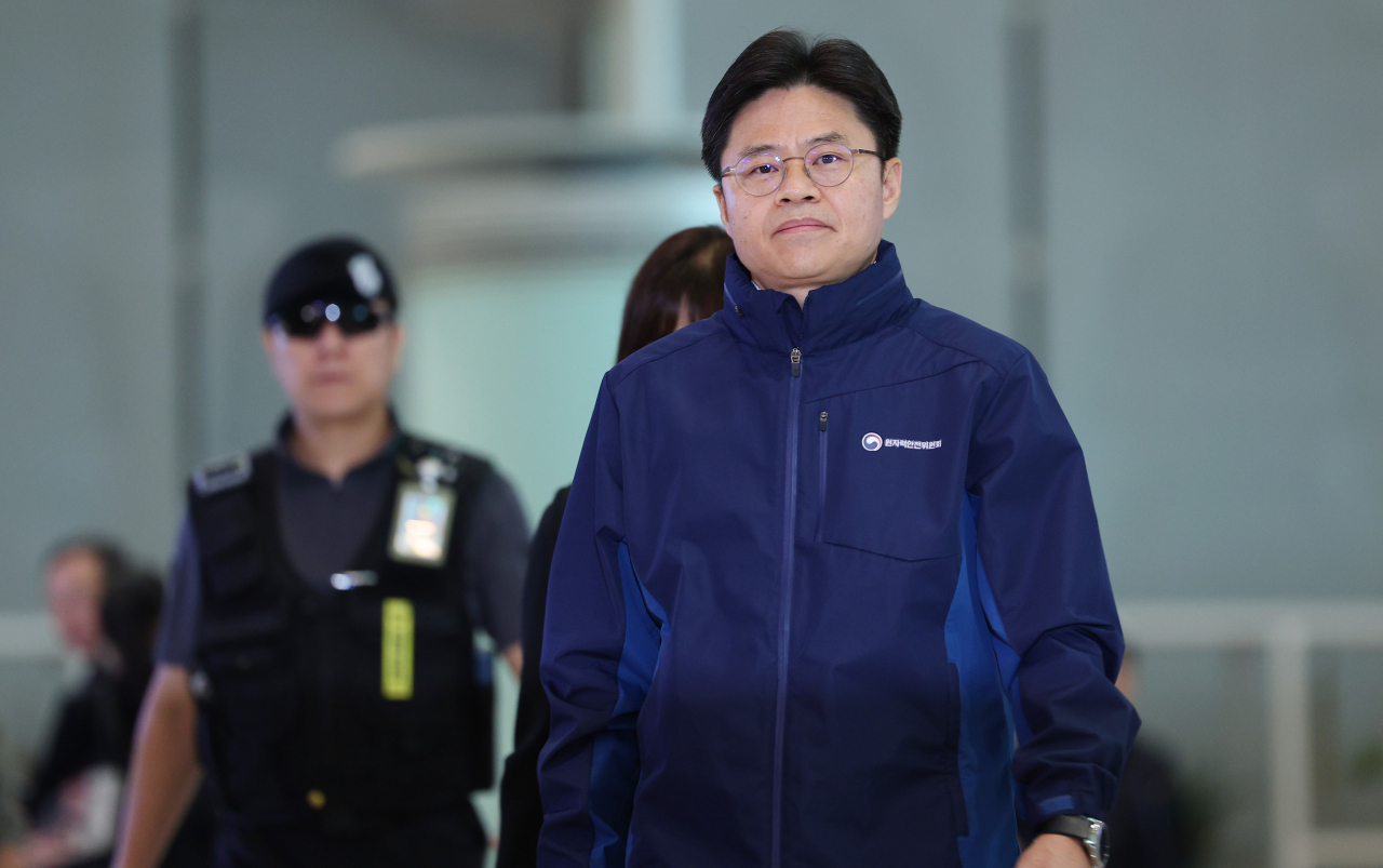 Yoo Guk-hee (right), Seoul's Fukushima Daiichi wastewater inspection team chief, is seen departing from Incheon Airport to Japan Sunday morning. (Yonhap)