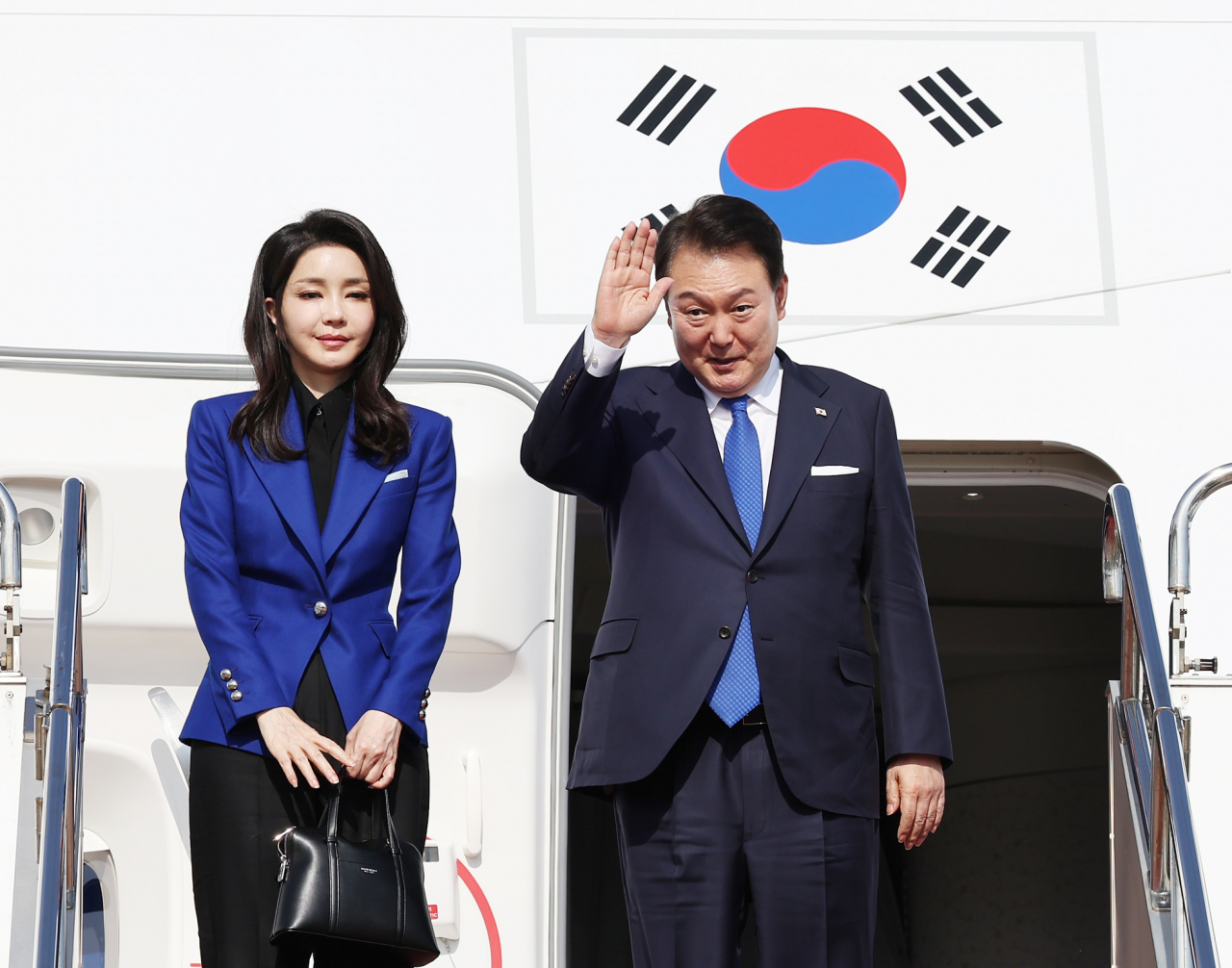 주요 7개국(G7) 정상회의 일정을 마친 윤석열 대통령과 부인 김건희 여사가 21일 일본 히로시마 공항에서 귀국길에 오르며 환송객들에게 손을 들어 인사하고 있다. [연합]