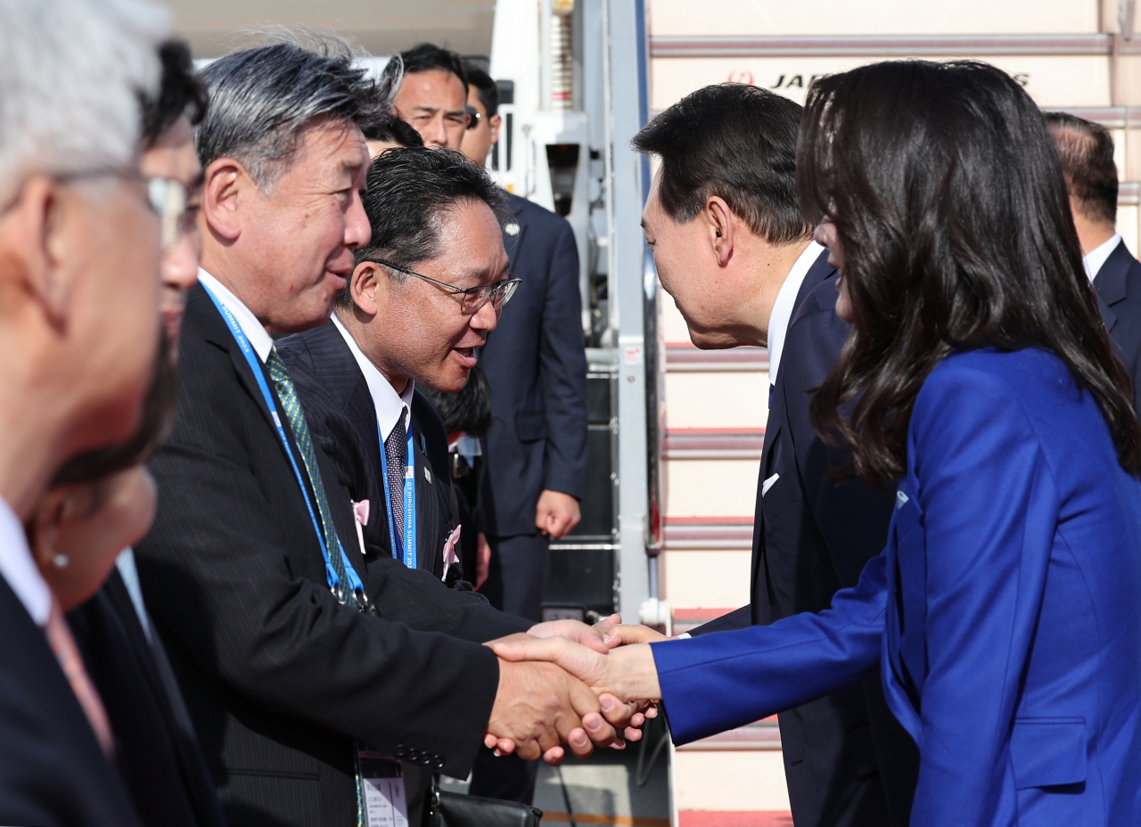 주요 7개국(G7) 정상회의 일정을 마친 윤석열 대통령과 부인 김건희 여사가 21일 일본 히로시마 공항에서 귀국길에 오르며 환송인사들과 악수하고 있다. [연합]