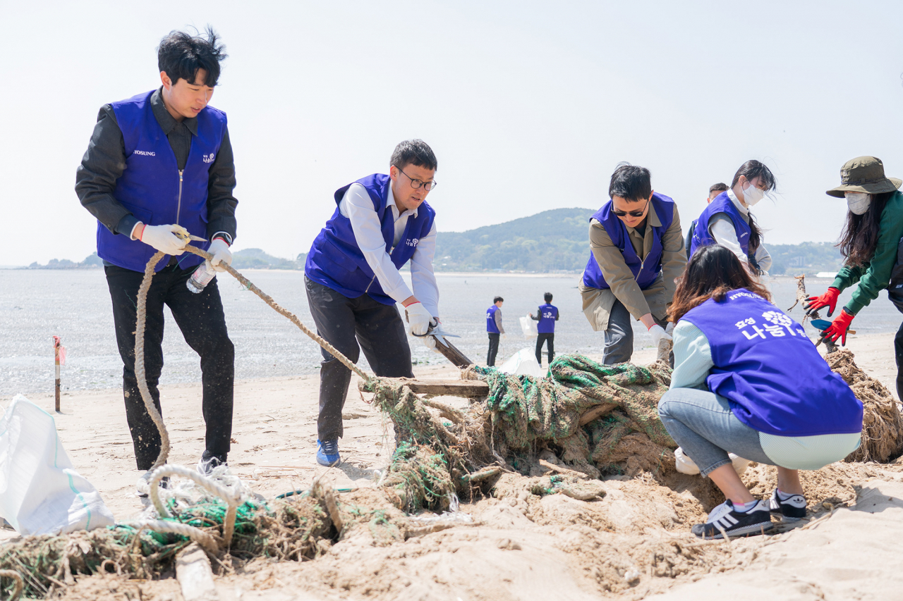 효성첨단소재 임직원들이 인천 영종도 용유해변에서 반려해변 정화 활동을 하고 있다. [효성 제공]