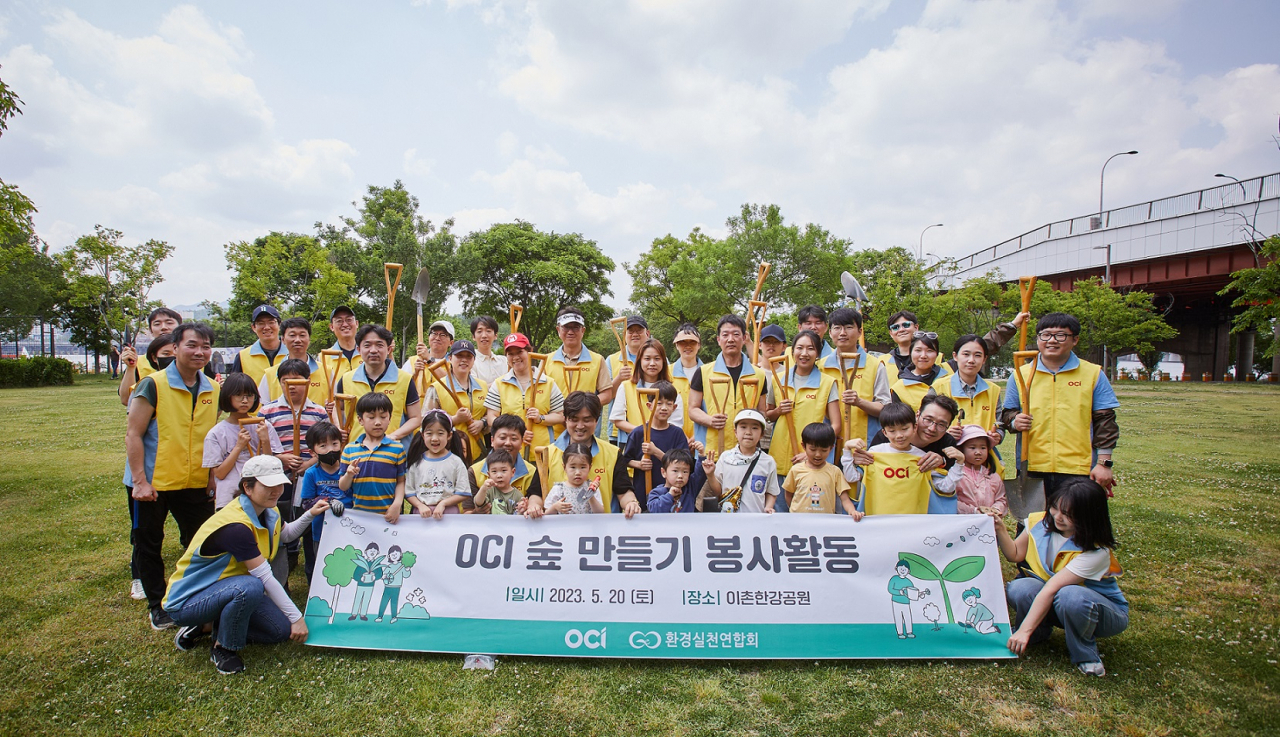 OCI 홀딩스 임직원과 가족들이 지난 20일 서울 이촌한강공원에서 ‘OCI 숲’ 만들기 봉사활동을 진행하고 기념촬영을 하고 있다. [OCI 홀딩스 제공]