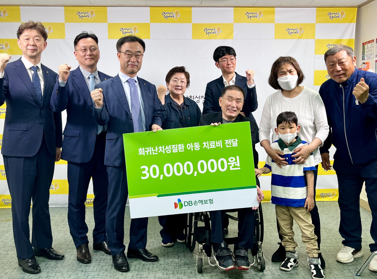 지난 19일 서울시 연희동에 위치한 한국희귀난치성질환 연합회 본부에서 박성식 DB손해보험 부사장(왼쪽 세 번째) 및 임직원들과 환우 가족, 연합회 직원들이 참석한 가운데 치료비 전달 및 기념촬영을 하고있다. [DB손해보험 제공]