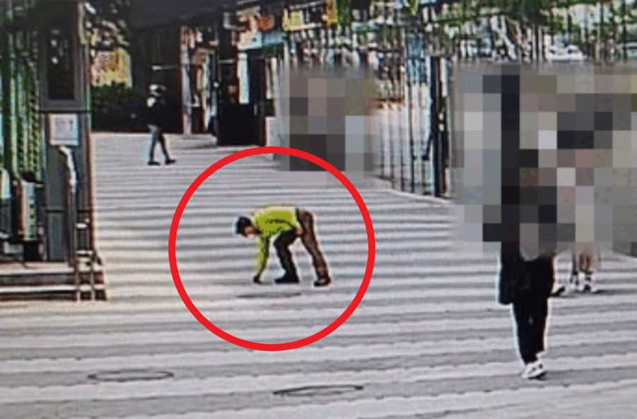 지난 18일 오전 11시27분 서울 광진구 한 길거리에서 70대 트럭 운전기사 A씨가 땅에 흘려진 다이아몬드 팔찌를 줍고 있다. [광진경찰서]