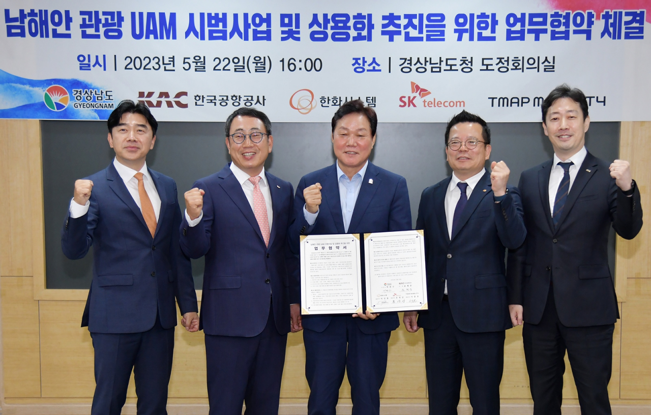 이종호(왼쪽부터) 티맵모빌리티 대표이사, 유영상 SK텔레콤 사장, 박완수 경남도지사, 어성철 한화시스템 대표이사, 윤형중 한국공항공사 사장이 기념 사진을 촬영하고 있다. [한화시스템 제공]