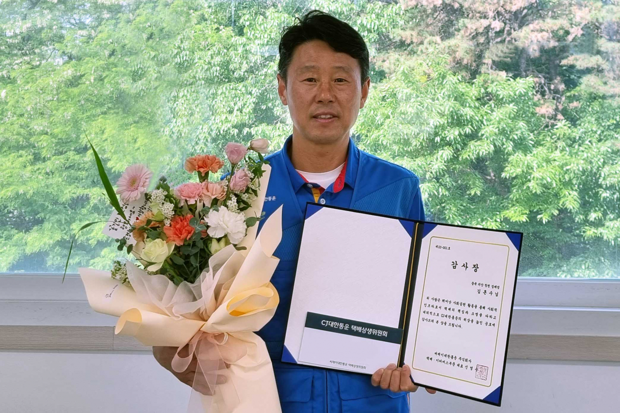 CJ대한통운 택배기사 김흔수씨가 감사장을 받고 기념사진을 촬영하고 있다. [CJ대한통운 제공]