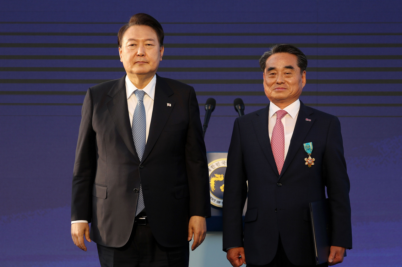 윤석열 대통령이 23일 서울 용산 대통령실 잔디마당에서 열린 ‘2023 대한민국 중소기업인대회’에서 이상우 아이엔아이 대표이사에게 철탑산업훈장을 포상한 뒤 기념 촬영을 하고 있다. [연합]