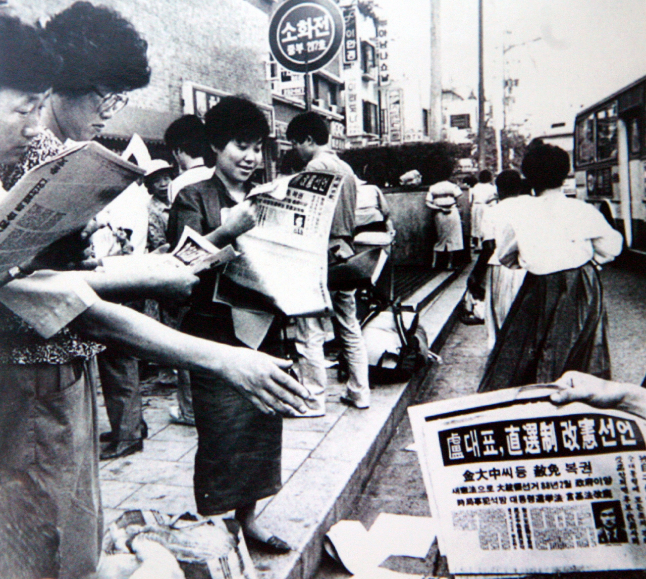 People read newspaper extras carrying the news of the June 29 Declaration by Roh Tae-woo in this June 29, 1987, file photo in Myeong-dong, Seoul. (Herald DB)