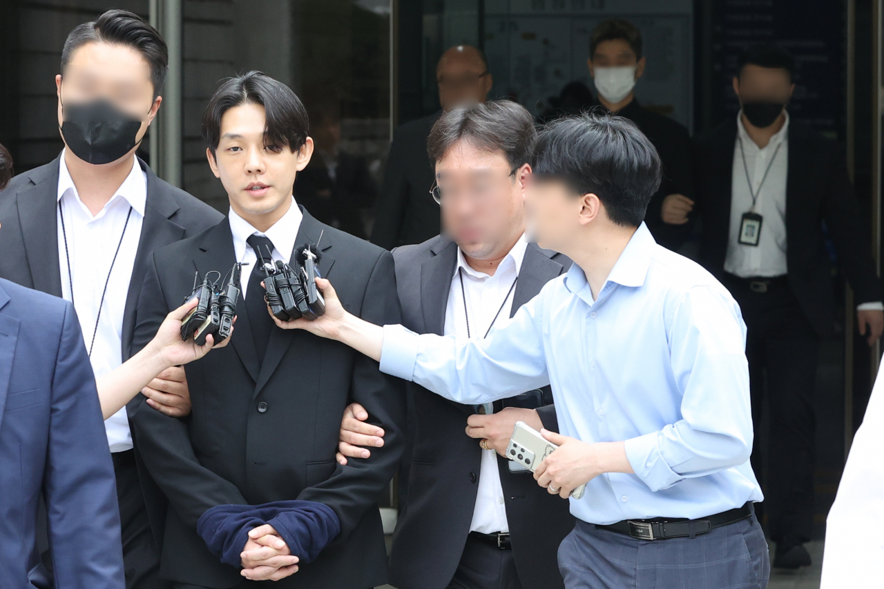 마약 투약 혐의를 받고 있는 배우 유아인과 유씨의 지인인 작가 A 씨가 24일 오후 서울중앙지방법원에서 영장실질심사를 마치고 호송차량으로 이동하고 있다. [연합]
