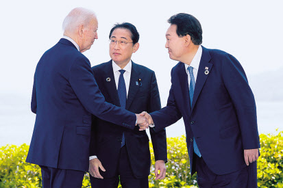 윤석열(오른쪽) 대통령과 조 바이든(왼쪽) 미국 대통령이 지난 21일 일본 히로시마에서 주요 7개국(G7) 정상회의를 계기로 열린 한미일 정상회담을 앞두고 기시다 후미오 일본 총리가 지켜보는 가운데 악수하고 있다. [연합]