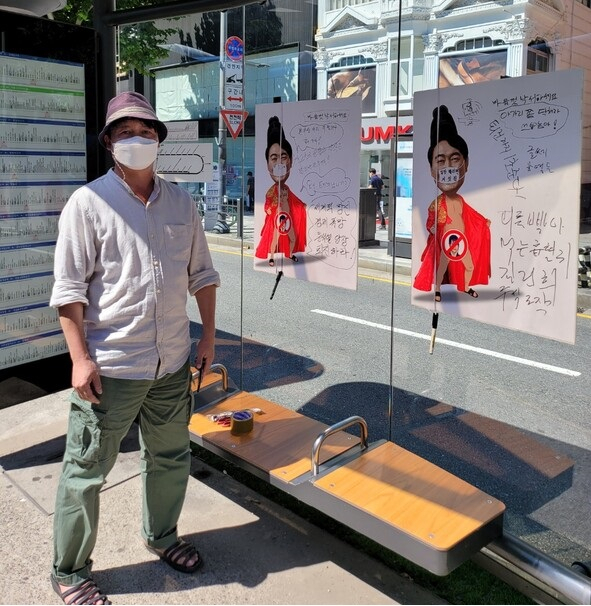 윤석열 대통령 풍자 포스터가 붙은 풍자 포스터 앞에서 이하 작가. [이하 작가 SNS]