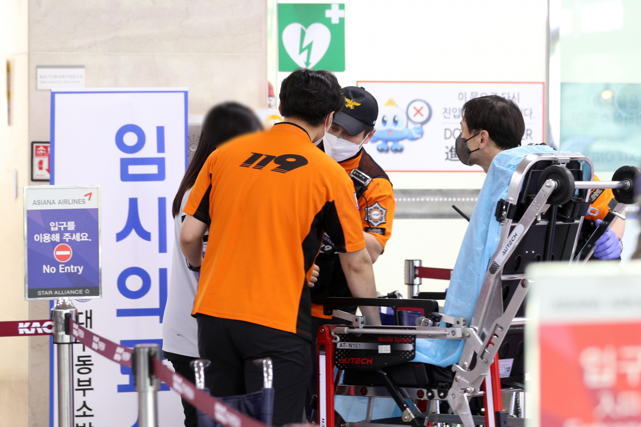 26일 오후 대구국제공항에 비상착륙한 비행기에서 몸에 이상이 있는 해당 비행기 탑승객이 119에 의해 긴급 이송되고 있다. [연합뉴스]