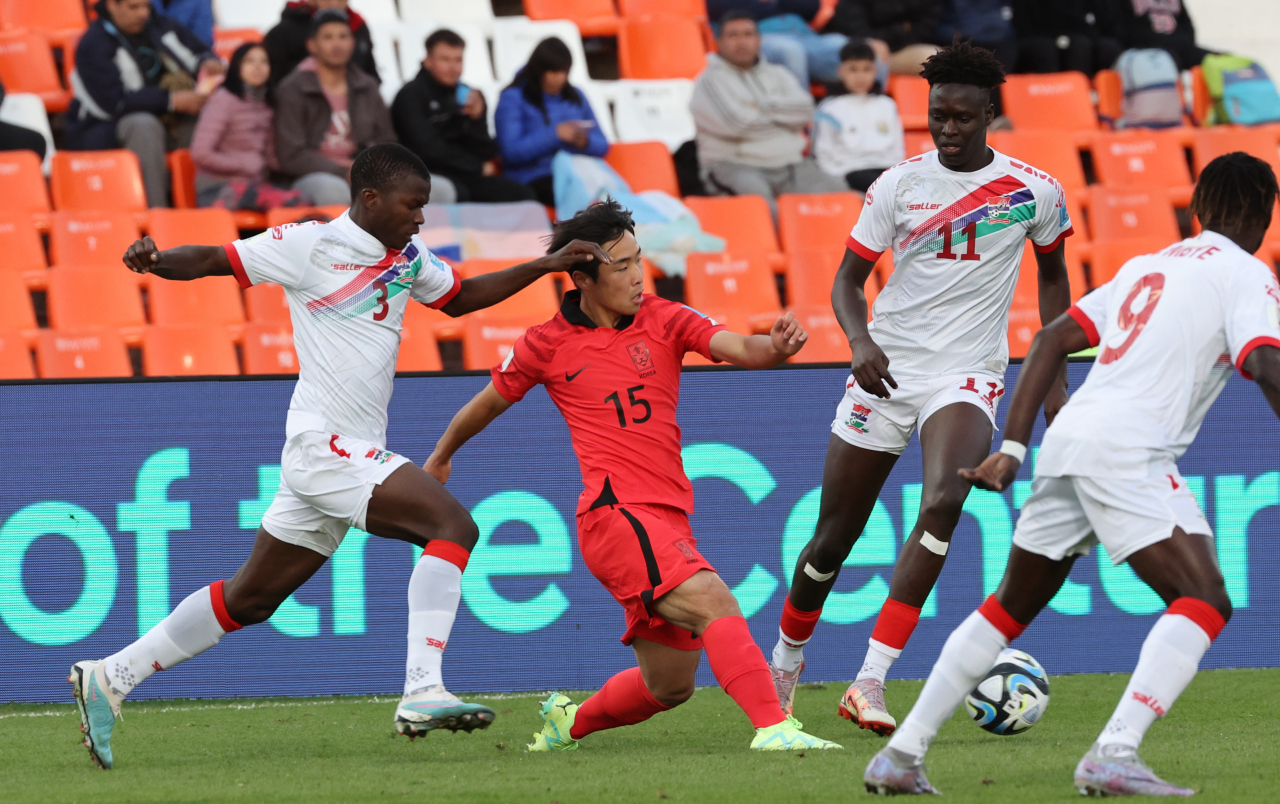 Cho Young-kwang of South Korea (center) makes a pass between Sainey Sanyang (left) and Modou Lamin Marong (right) of Gambia during the teams' Group F match at the FIFA U-20 World Cup at Estadio Malvinas Argentinas in Mendoza, Argentina last Sunday. (Yonhap)