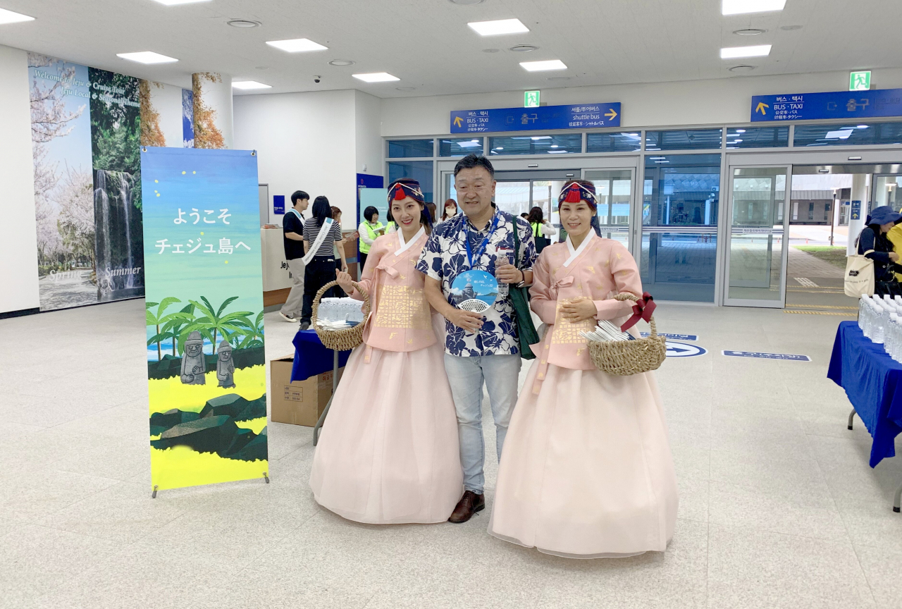 한복 입은 제주 스태프들과 기념촬영하는 일본인 크루즈 관광객