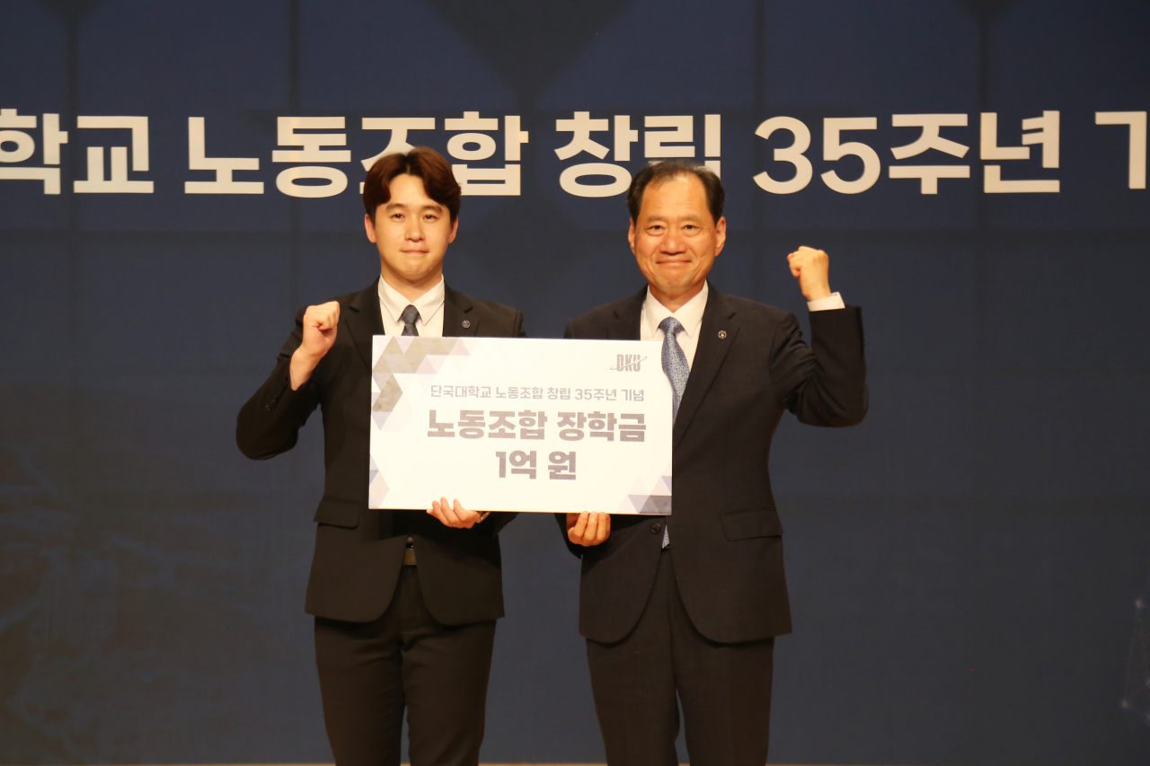 노동조합 창립 시기(1988.5월)에 태어난 조영헌 선생(행정법무대학원/왼쪽)이 김수복 총장에게 대학발전기금 1억원을 대표로 전달하고있다.[단국대 제공]