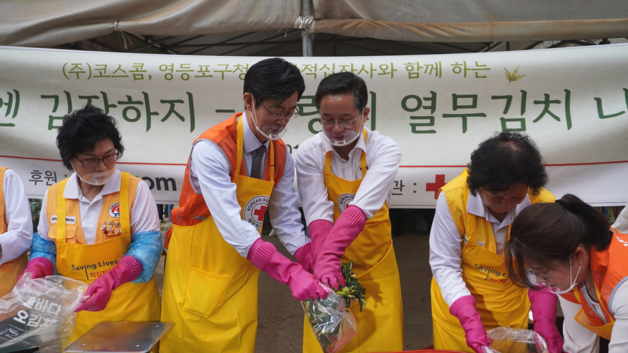 1일 서울 영등포구에 위치한 문래텃밭에서 사랑의 열무김치 나눔 행사에 참석한 황선정(왼쪽 두 번째) 코스콤 전무이사와 최호권(왼쪽 세 번째) 영등포구청장이 대한적십자사 봉사자들과 함께 김장을 하고 있는 모습. [코스콤]