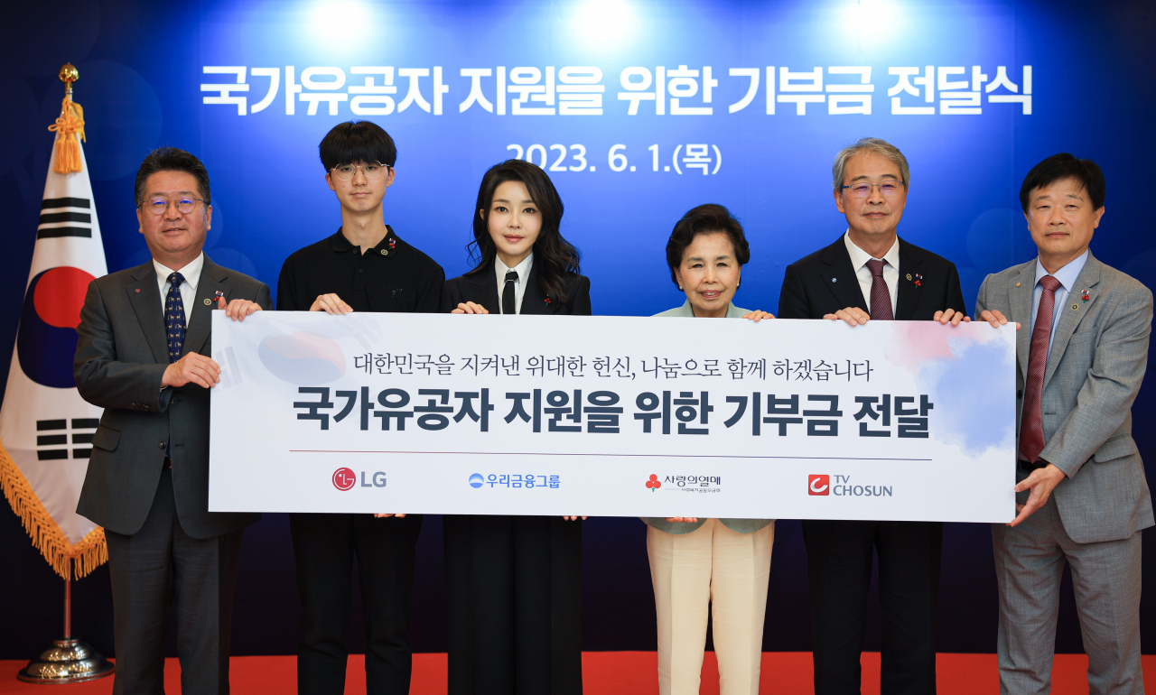 김건희 여사가 1일 서울 중구 사랑의열매 회관에서 열린 국가유공자 지원을 위한 기부금 전달식에서 참석자들과 기념촬영을 하고 있다. [연합]