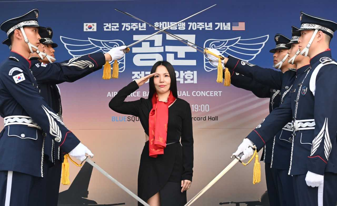 공군은 1일 서울 용산 블루스퀘어에서 열린 ‘2023 공군 정기음악회’에 앞서 가수 알리를 홍보대사로 선정하고 위촉식을 실시했다. 알리가 공군 조종사의 상징인 빨간마후라를 매고 경례를 하고 있다. [공군 제공]