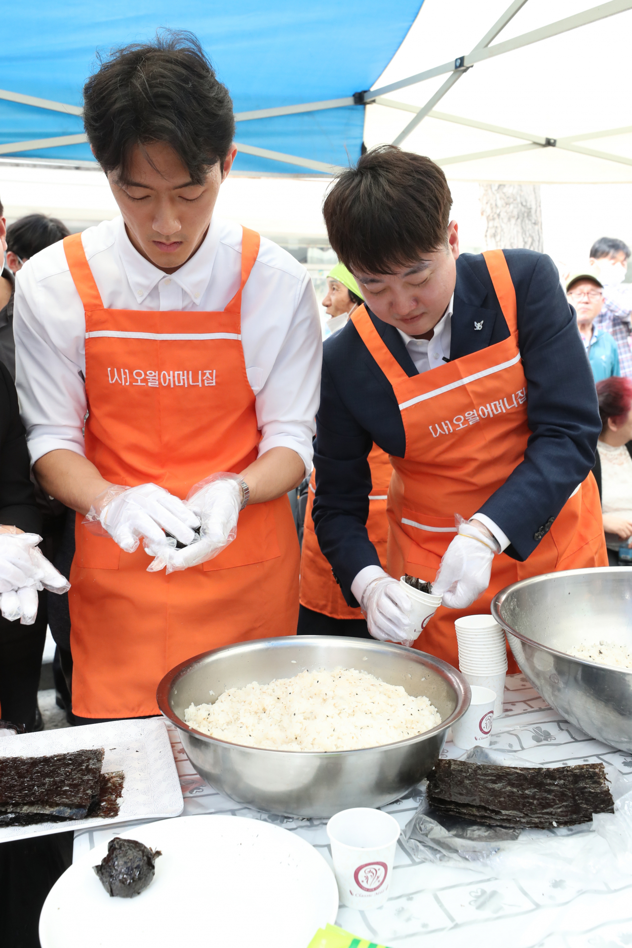 전직 대통령 고 전두환씨의 손자 전우원씨가 지난달 17일 광주 동구 금남로에서 열린 5·18 시민 난장 오월 주먹밥 체험 부스에서 국민의힘 이준석 전 대표와 주먹밥을 만들고 있다. [연합]