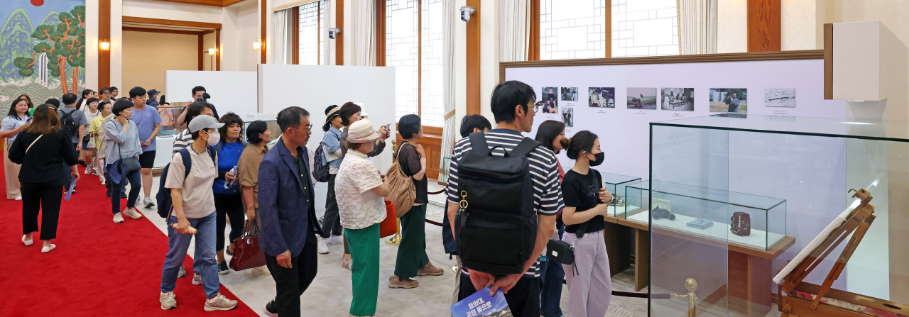 지난 4일 서울 청와대 본관에서 열린 청와대 개방 1주년 기념 '우리 대통령들의 이야기-여기 대통령들이 있었다' 를 방문한 관람객들이 전시물을 살펴보고 있다. [연합]