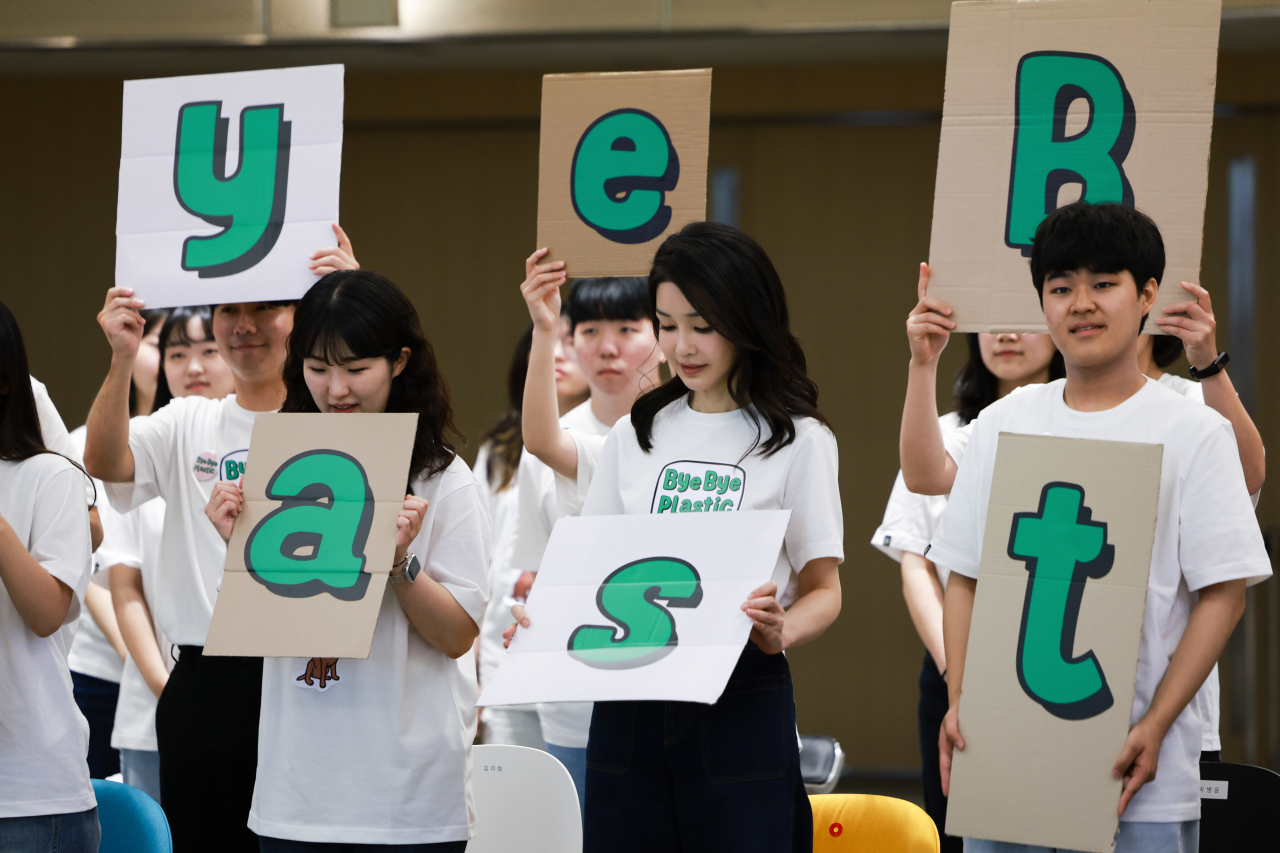 김건희 여사가 5일 서울 성북구 고려대 SK미래관에서 열린 ‘바이바이플라스틱(Bye Bye Plastic)’ 캠페인 출범 행사에서 대학생들과 함께 폐박스로 만든 '바이바이 플라스틱' 문구를 들어 보이고 있다. [연합]