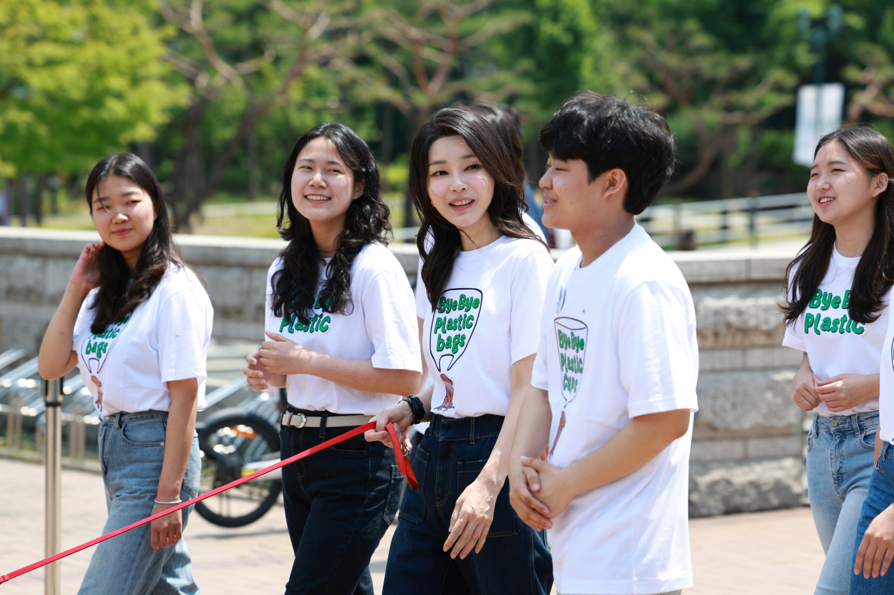 김건희 여사가 5일 서울 성북구 고려대에서 열린 ‘바이바이플라스틱(Bye Bye Plastic)’ 캠페인에서 대학생들과 함께 ‘바이바이 플라스틱’ 문구가 새겨진 티셔츠를 입고 캠페인 활동을 하고 있다. [연합]