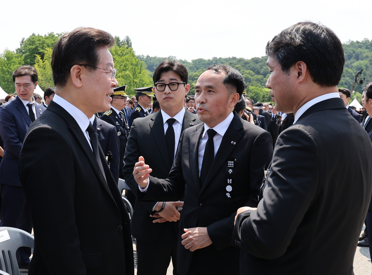 이재명 더불어민주당 대표(왼쪽)가 6일 서울 동작구 국립서울현충원에서 열린 제68회 현충일 추념식장에서 추념식이 끝난 뒤 최원일 전 천안함장(가운데)으로부터 항의를 받고 있다. [연합]
