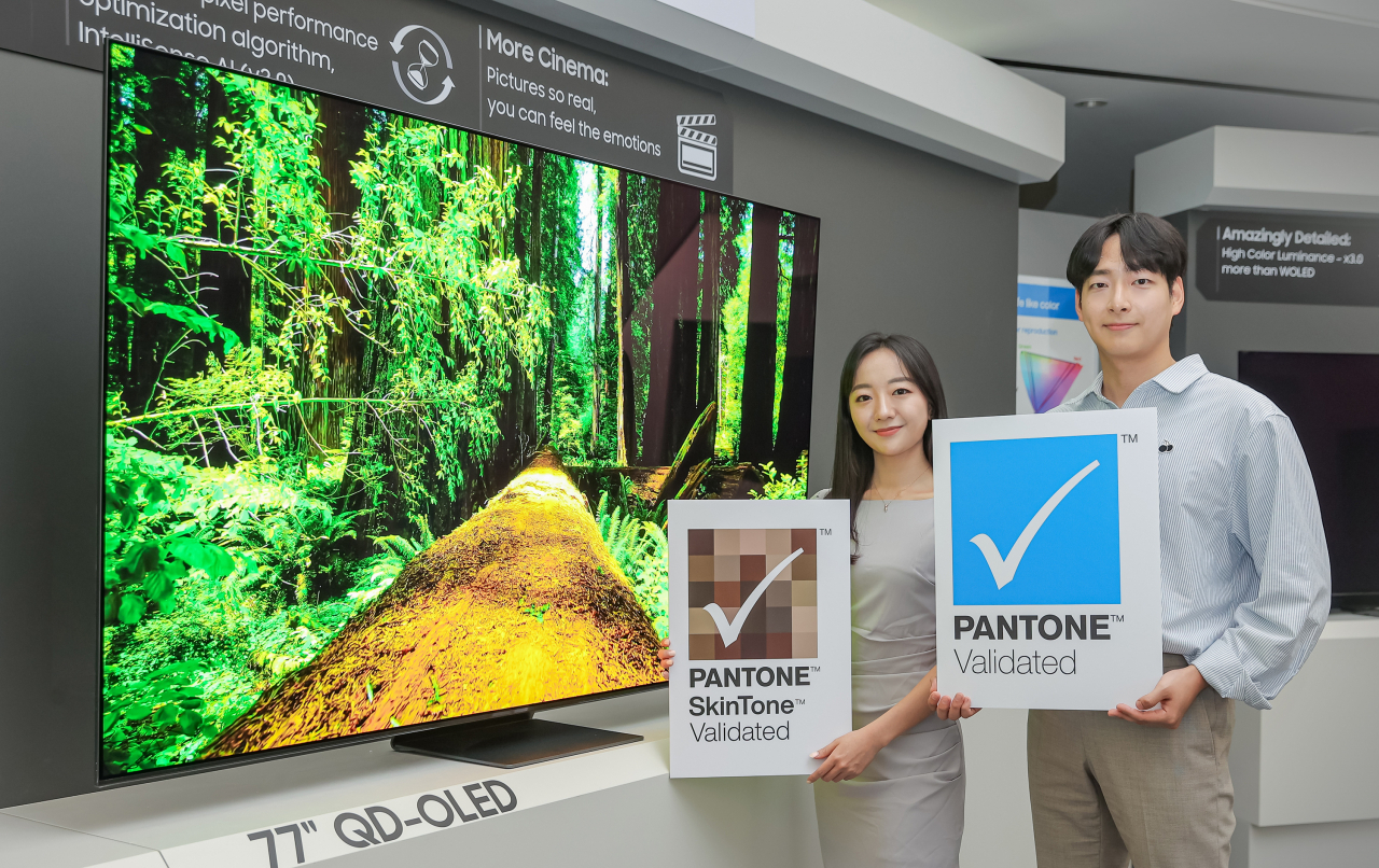 : 삼성디스플레이 직원들이 TV용 QD-OLED 앞에서 '팬톤 컬러 인증' 및 '팬톤 스킨톤 인증' 로고를 들고 기념 촬영을 하고 있다.[삼성디스플레이 제공]