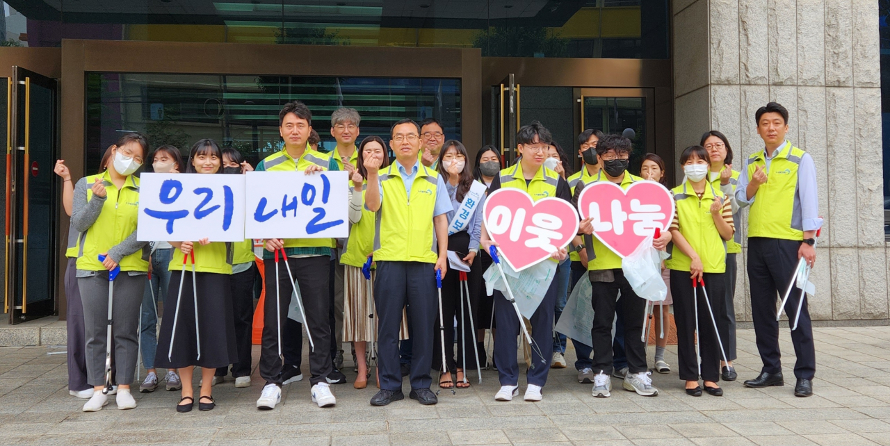 노사발전재단 김대환 사무총장(가운데)과 직원들이 7일 오전 마포공덕시장 주변 환경정화 활동을 펼친 후 기념사진을 촬영하고 있다. [노사발전재단 제공]