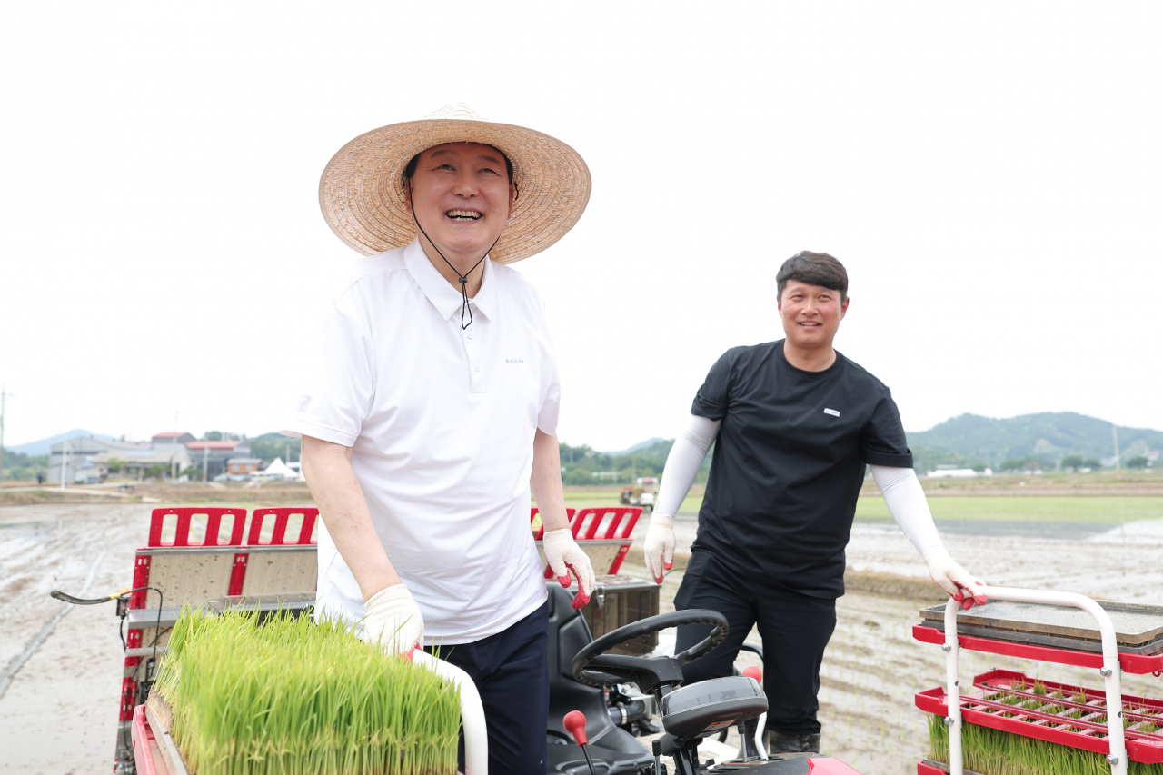 윤석열 대통령이 7일 충남 부여군 임천면의 '꿈에영농조합법인' 모내기 현장을 방문, 농민과 함께 이앙기에 올라 밝게 웃고 있다. [연합]