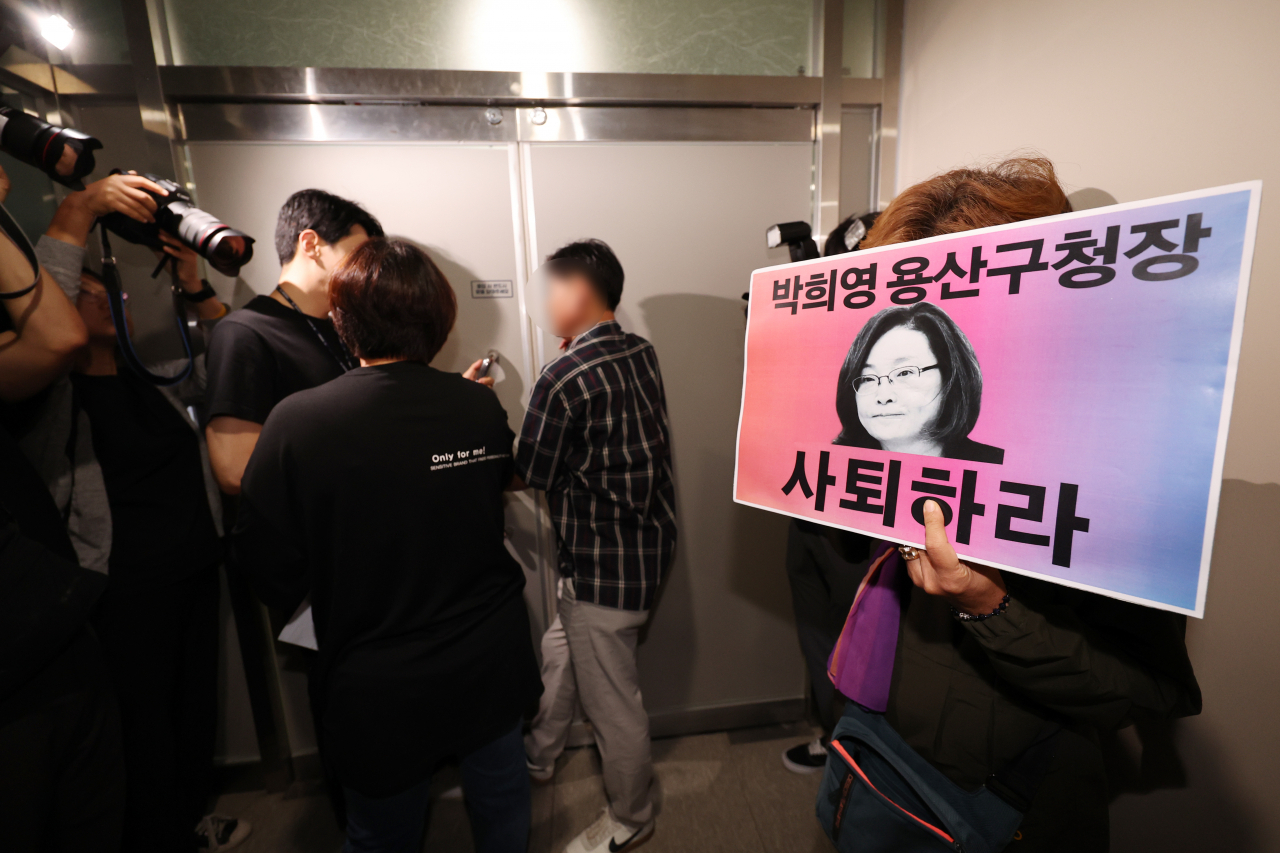 지난 8일 오전 서울 용산구청에서 이태원 참사 유가족들이 이태원 참사 부실 대응 혐의로 구속기소 됐다 보석으로 석방된 박희영 용산구청장의 출근을 저지하며 사퇴를 촉구하는 손팻말을 들고 있다. [연합뉴스]