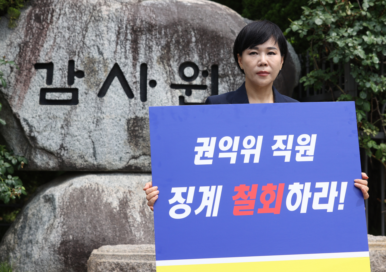 전현희 국민권익위원장이 감사원의 최종 감사 결과 발표를 앞둔 9일 오후 서울 종로구 감사원 앞에서 기자회견을 하기 앞서 "권익위 직원 징계 철회하라' 등이 적힌 팻말을 들고 있다. [연합]
