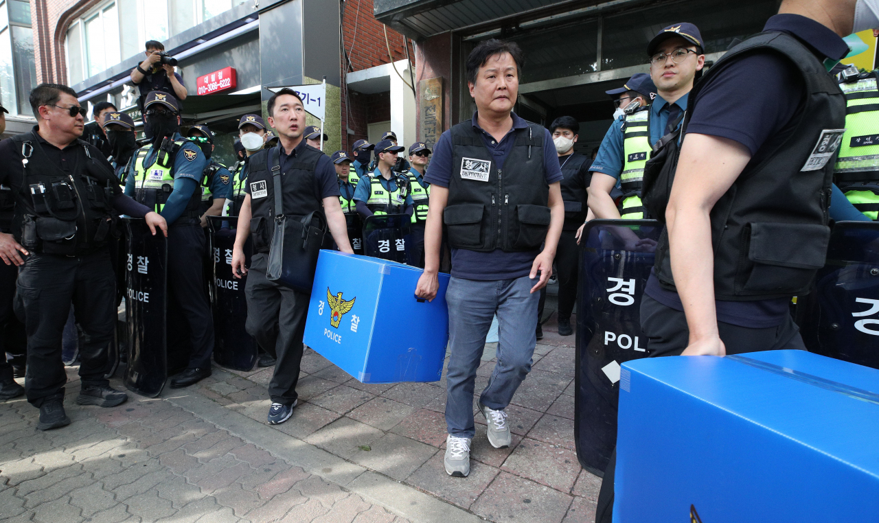 경찰이 9일 오후 서울 영등포구 대림동 전국건설노동조합에서 '1박 2일 집회' 관련 집시법 위반 등 혐의로 압수수색을 마친 뒤 압수품을 들고 차량으로 향하고 있다. [연합]