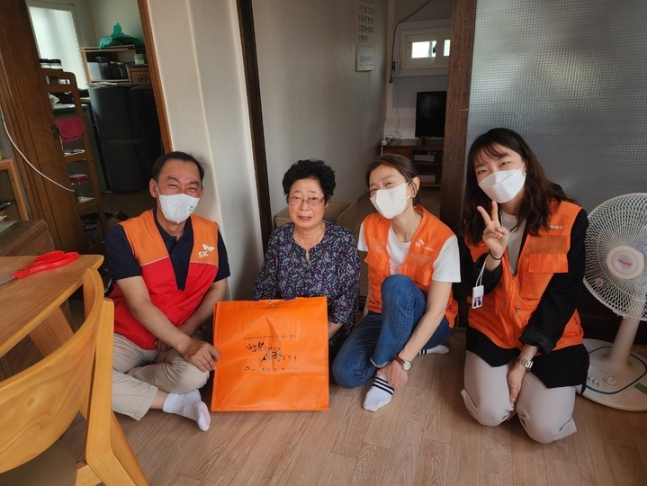 지난달 26일 ‘행복나눔 사랑잇기’ 대면 봉사활동에 참여한 명성(왼쪽) SK어스온 사장과 구성원들이 홀몸 어르신 가정을 방문해 기념사진을 촬영하고 있다.[SK이노베이션 제공]