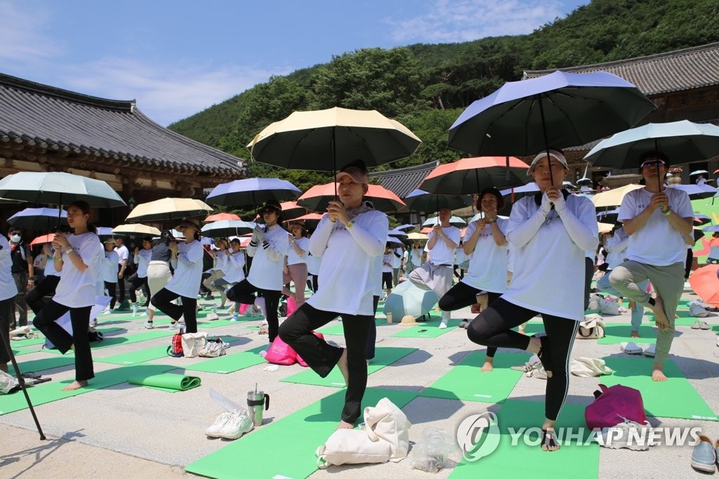 지난 10일 오전 전남 구례군 마산면 화엄사 각황전 앞마당에서 '제3회 지리산 대화엄사 요가대축제' 참가자들이 요가 수련을 하고 있다. [연합]