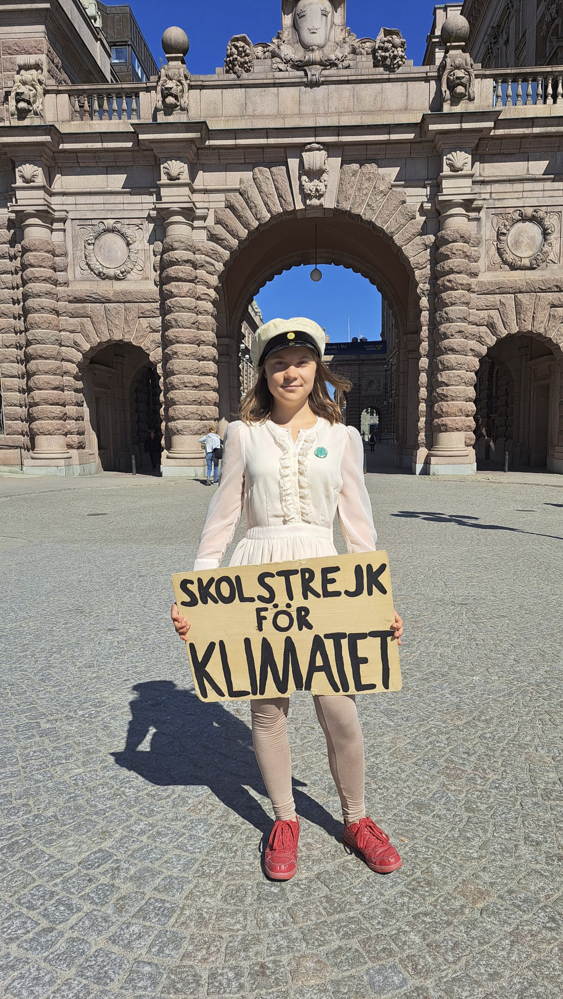 Greta Thunberg poses with a sign reading in Swedish