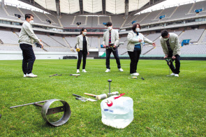 삼성물산 잔디환경연구소 직원들이 축구장 잔디 상태를 측정하는 모습