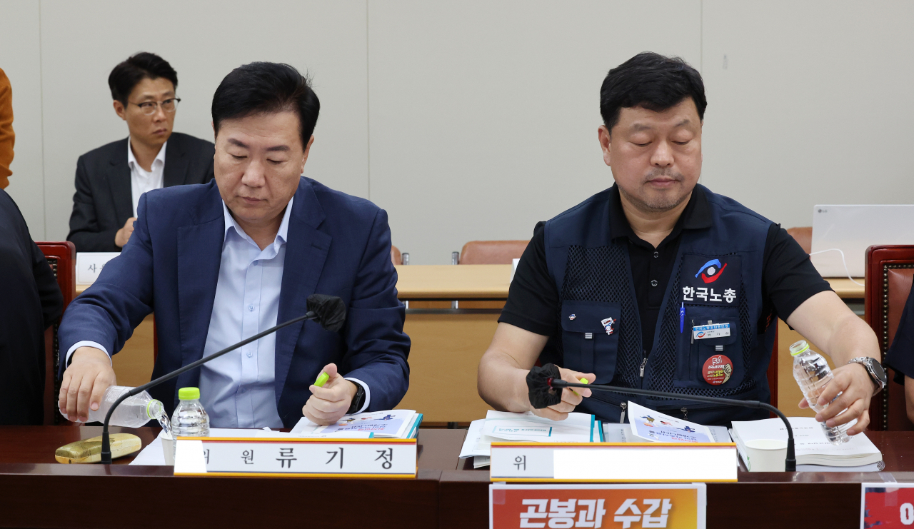 8일 오후 세종시 정부세종청사 최저임금위원회 회의실에서 열린 제3차 전원회의에서 사용자위원인 류기정 한국경영자총협회 전무(왼쪽)와 근로자위원인 류기섭 한국노총 사무총장이 물을 마시기 위해 생수통을 잡고 있다. [연합]