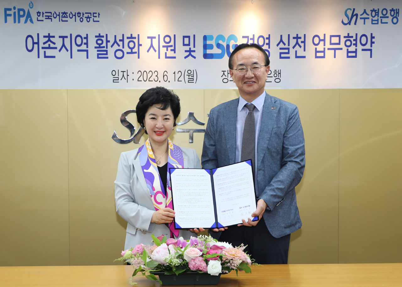 Sh수협은행은 12일 서울 송파구 수협은행 본사에서 한국어촌어항공단과 ‘어촌지역 활성화 지원 및 ESG경영 실천을 위한 업무협약’을 체결했다. 강신숙 수협은행 은행장(왼쪽)과 박경철 한국어촌어항공단 이사장이 협약서에 서명을 마치고 기념촬영을 하고 있다. [사진=수협은행]
