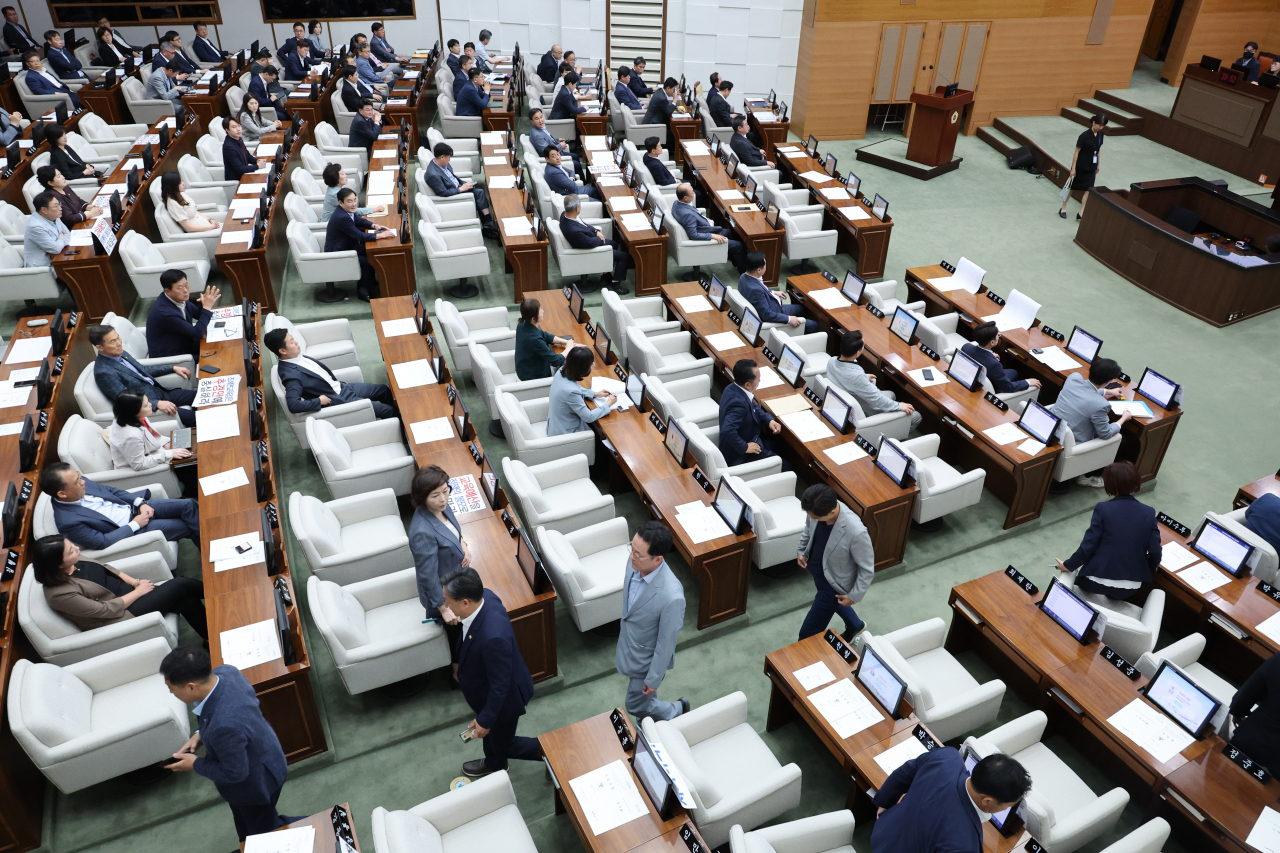 13일 오전 서울시의회에서 열린 제319회 정례회에서 더불어민주당 시의원들이 의사진행발언 요청이 받아들여지지 않자 퇴장하고 있다. 전날 열렸던 본회의는 조 교육감의 시정연설 내용을 수정하라는 국민의힘 측의 문제 제기로 10시간 가까이 정회되며 파행한 끝에 산회했다. [연합]