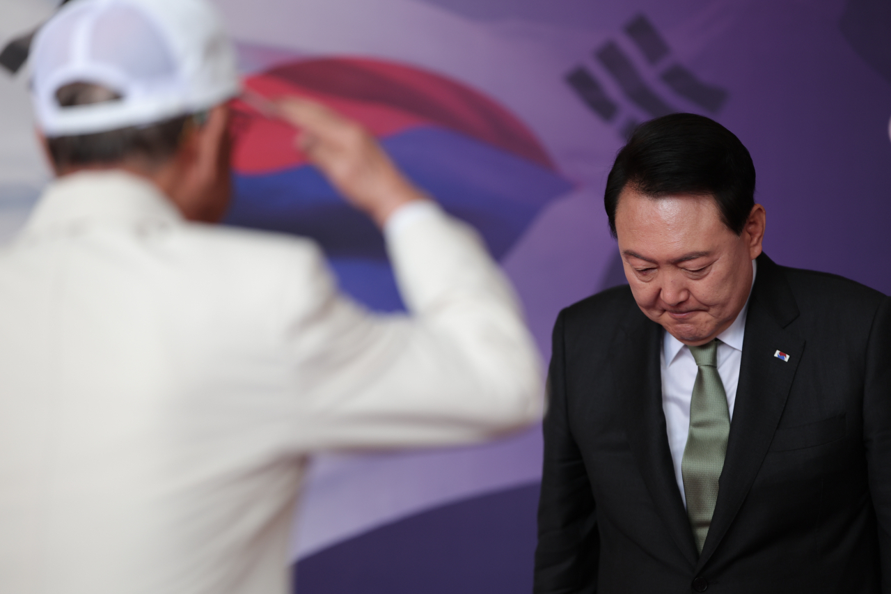 윤석열 대통령이 14일 청와대 영빈관에서 열린 국가유공자 및 보훈가족 초청 오찬에서 참석자들을 영접하며 한 국가유공자의 경례를 받고 있다. [연합]