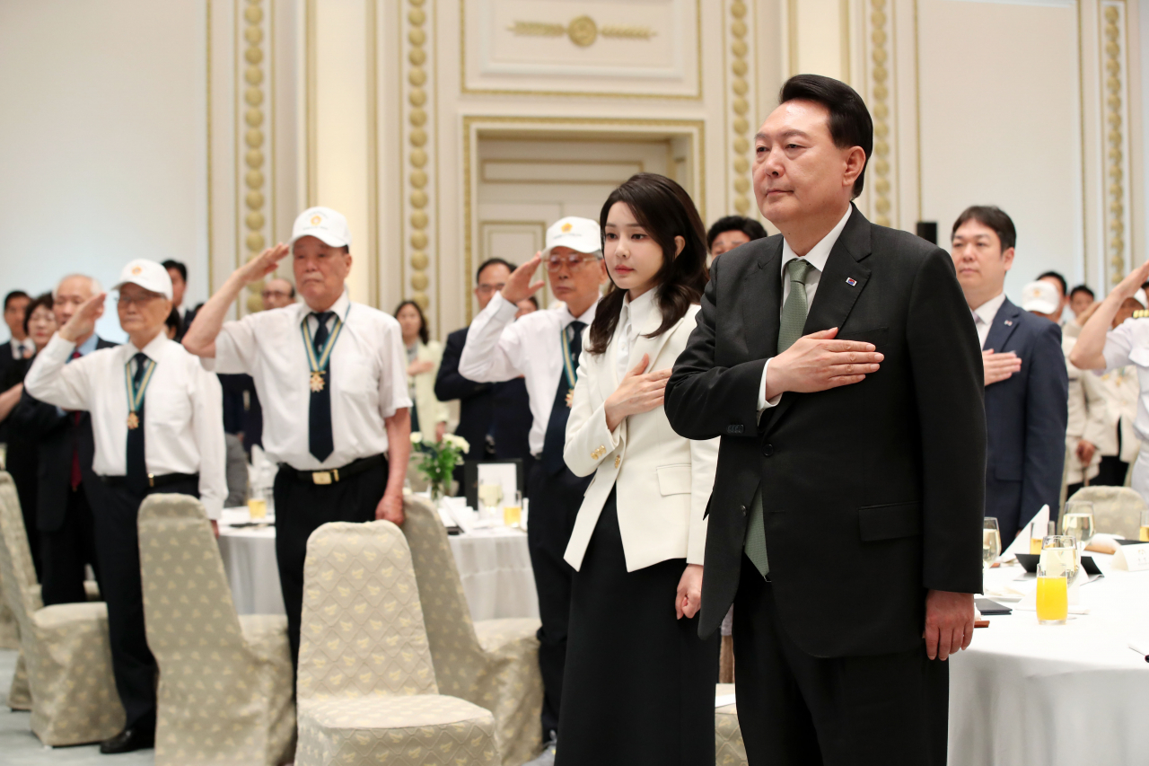 윤석열 대통령과 김건희 여사가 14일 청와대 영빈관에서 열린 국가유공자 및 보훈가족 초청 오찬에서 국기에 경례하고 있다. [연합]