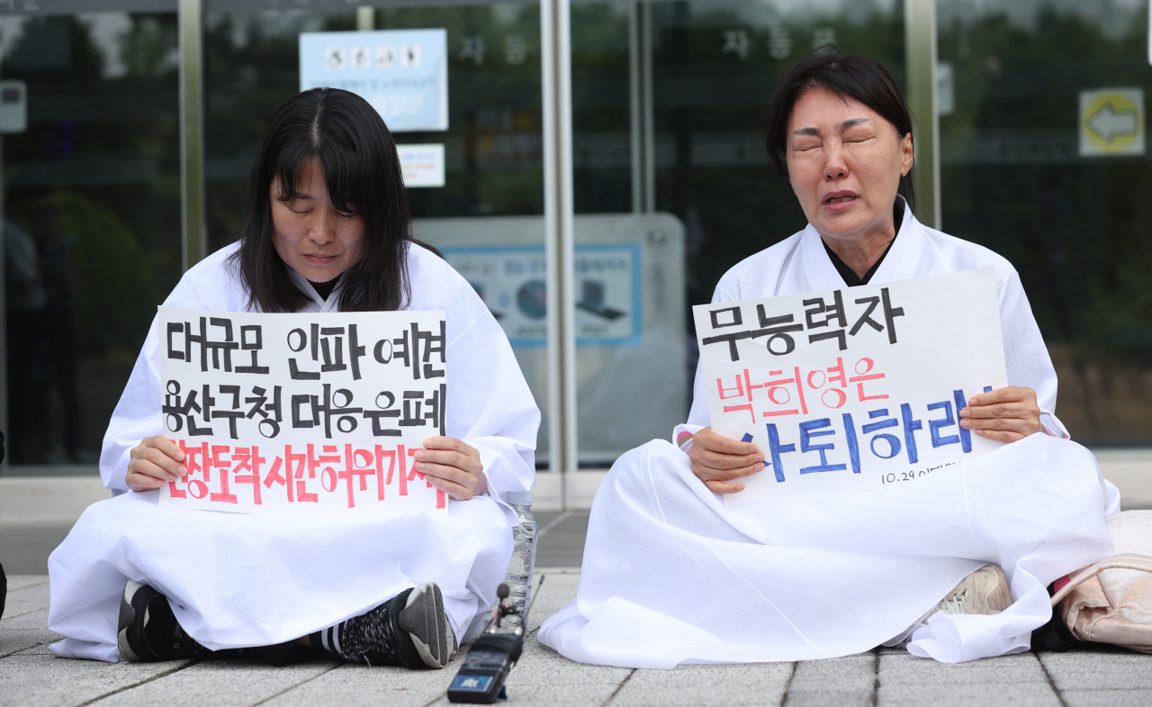 12일 오전 서울 용산구청 앞에서 10·29 이태원참사 유가족 협의회가 연 기자회견에 참가한 유가족들이 박희영 용산구청장의 사퇴를 촉구하는 손팻말을 들고 있다. 연합뉴스