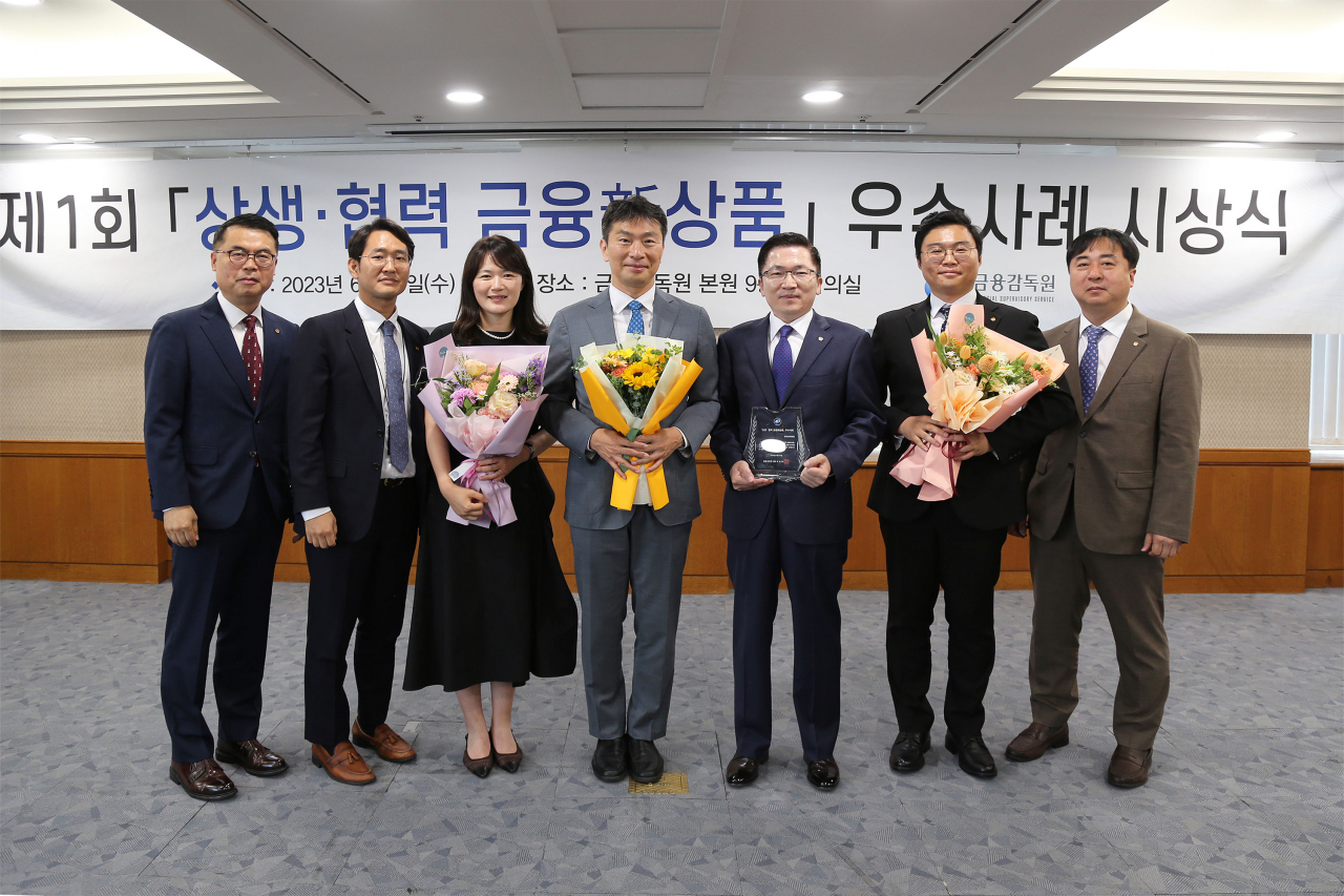 나채범 한화손해보험 대표이사(오른쪽 세 번째) 및 임직원들이 14일 서울 여의도 금융감독원에서 열린 '제1회 상생·협력 금융신상품 우수사례 시상식'에서 이복현 금융감독원장(가운데)과 함께 기념촬영을 하고 있다. [한화손해보험 제공]