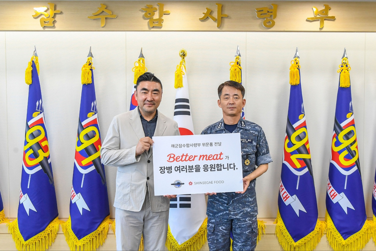 14일 경남 창원시 진해구에 위치한 해군 잠수함사령부에서 신세계푸드가 국가전략부대인 잠수함사령부 장병들의 식문화향상을 위해 대안육 ‘베러미트(Better Meat)’ 식물성 런천 캔햄, 베러 핫도그, 만두, 미트볼을 넣은 토마토 소스 등의 제품 5000여 개를 전달했다. 신세계푸드의 송현석(왼쪽) 대표와 해군 잠수함사령부의 이수열 사령관이 기념촬영을 하고 있다. [신세계푸드 제공]