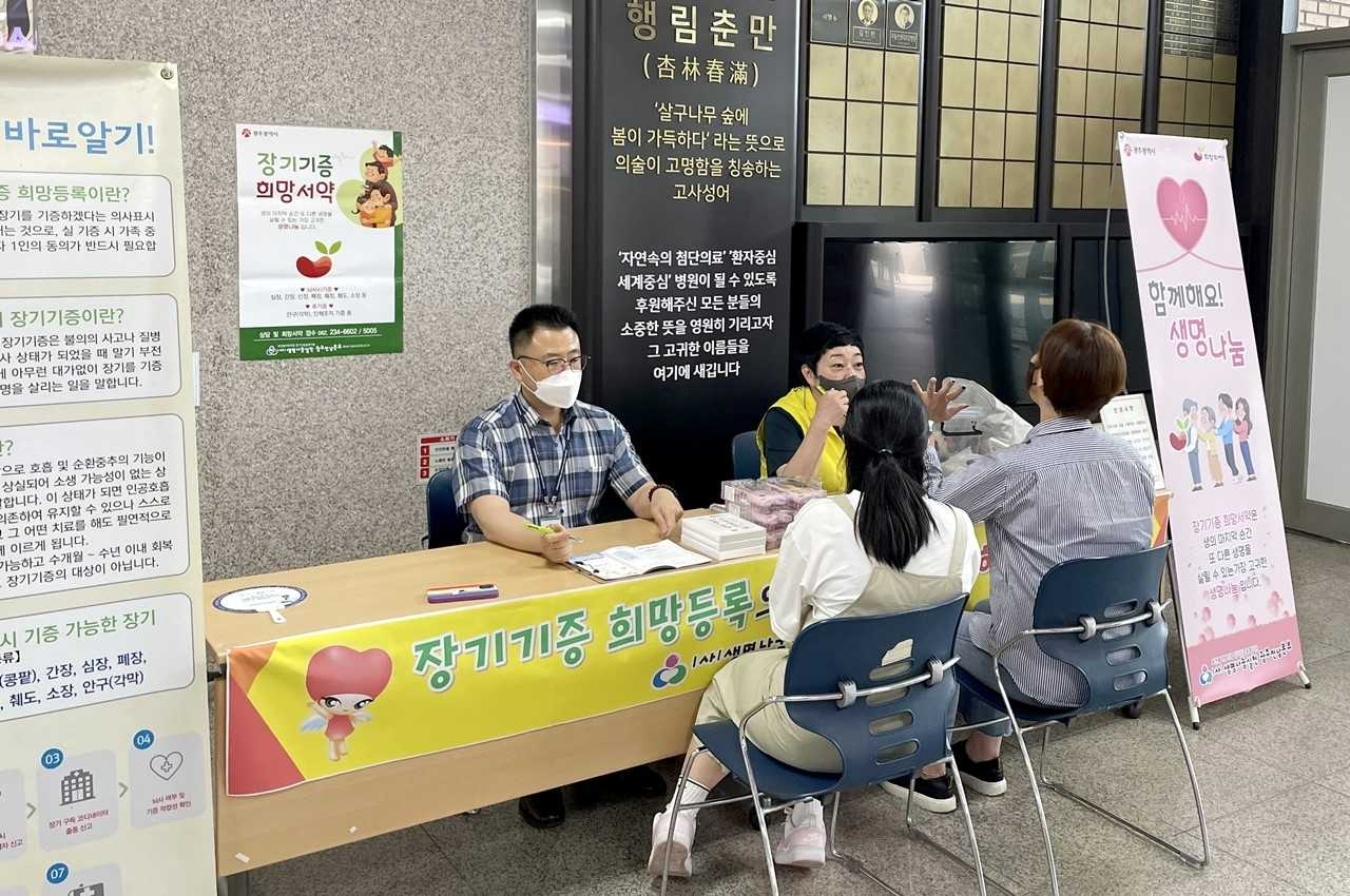 화순전남대학교병원 손오봉 사회사업팀장(왼쪽) 등이 병원 1층 로비에서 내원객을 대상으로 ‘찾아가는 장기기증 희망 등록 캠페인’에 대해 설명하고 있다.