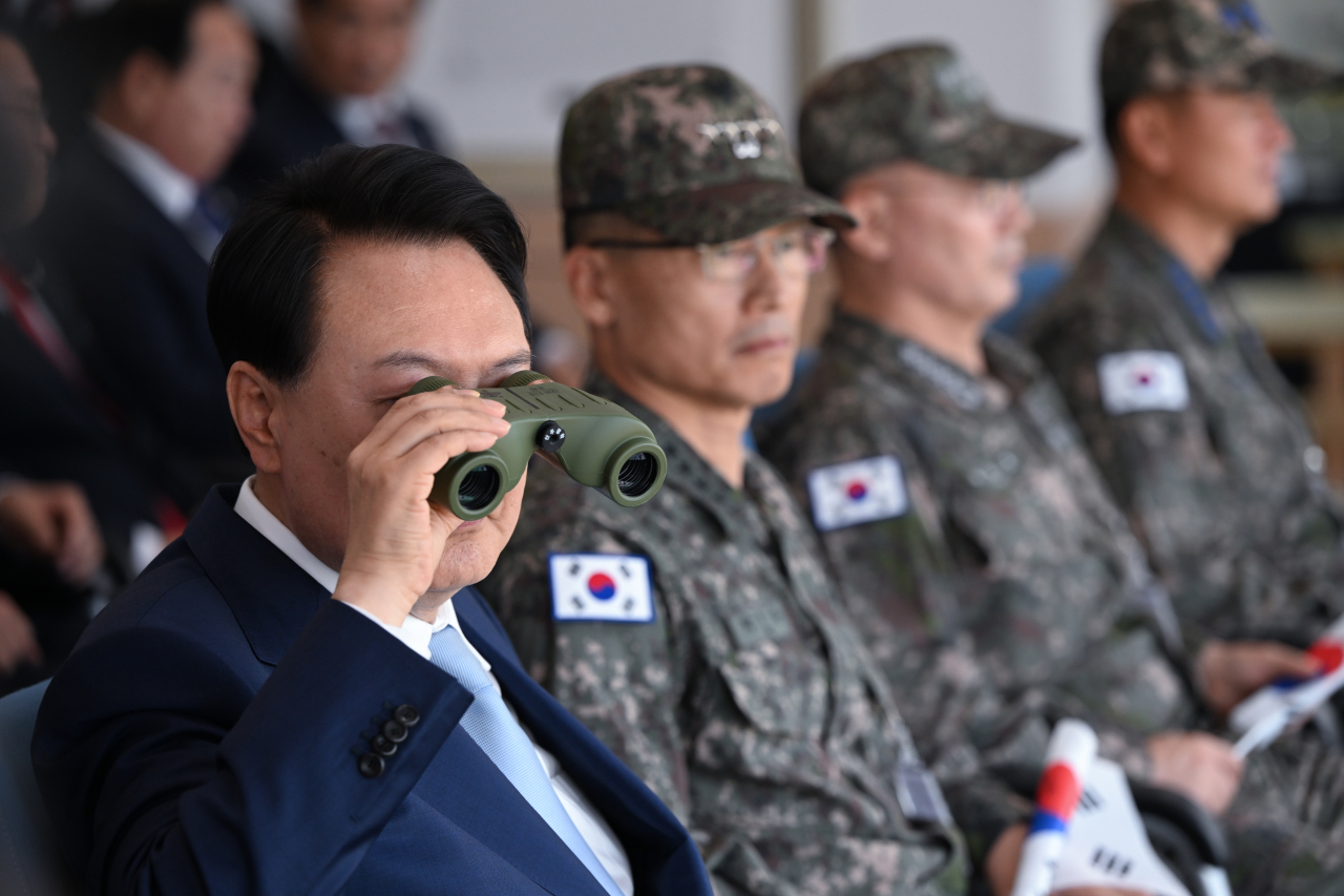 윤석열 대통령이 지난 15일 경기 포천 승진훈련장에서 실시된 '2023 연합·합동 화력격멸훈련'에서 쌍안경으로 훈련 현장을 주시하고 있다. [연합]