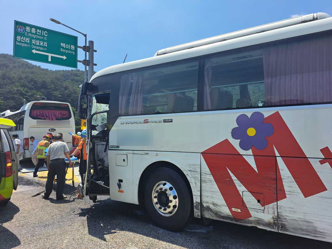 Rescuers transport an injured passenger from a bus after a rear-end collision in Hongcheon, Gangwon Province, Friday. (Yonhap)
