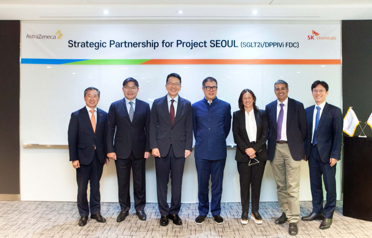 From left: Kim Yoon-ho, SK Chemical’s pharmaceutical unit CEO; Ahn Jae-hyun, SK Chemical CEO; Chey Chang-won, SK Discovery vice chairman; Leon Wang, executive vice president of AstraZeneca’s international business; Sylvia Varela, vice president of AstraZeneca’s Asia business; Ankush Nandra, chief financial officer of AstraZeneca’s international business; and Kim Sang-pyo, country president of AstraZeneca Korea pose for a picture at a partnership ceremony held in Pangyo, Gyeonggi Province, Monday. (SK Chemical)