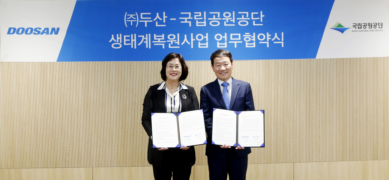 박영호(오른쪽) 두산 부사장이 손영임 국립공원공단 자원보전이사와 협약식 이후 기념사진을 촬영하고 있다. [두산 제공]